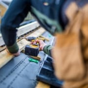 mand borer i træ på tag