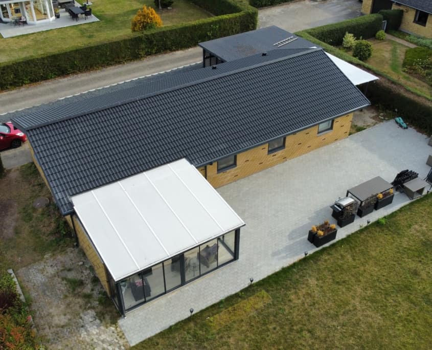 Sort tag på gult murstenshus